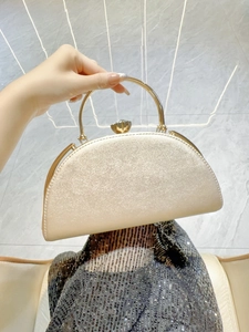 Detail of champagne gold evening clutch with glitter finish and metallic round handle