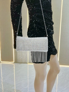 Detail of silver rhinestone clutch with long crystal fringes and sleek metal chain
