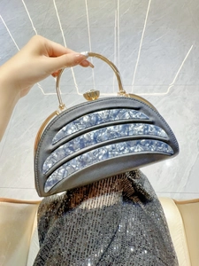 Detail of half-moon evening clutch with marble acrylic trim and gem-encrusted clasp