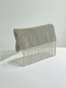 Close-up of sparkling silver rhinestone evening clutch bag with long crystal tassel fringe