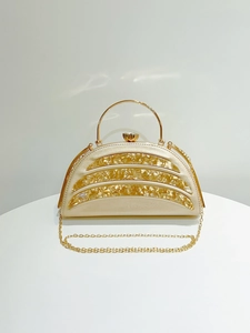 Detail of evening bag with champagne gold semi-circle acrylic panels and gemstone clasp