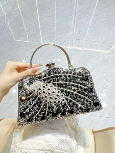 Detail view of a luxury rhinestone peacock evening clutch with a metal ring handle