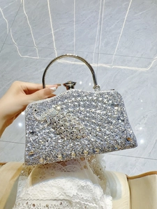 Close-up of sparkling silver rhinestone evening clutch bag with round metal handle
