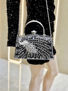 Detail of luxury rhinestone evening bag featuring a crystal peacock and silver handle