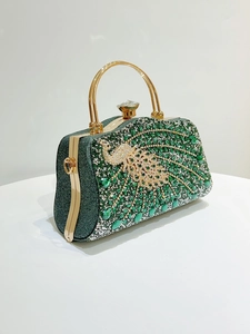 Detailed close-up of a luxury green crystal evening bag featuring a jeweled peacock motif