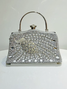 Close-up of sparkling silver rhinestone evening bag with a luxury crystal peacock pattern
