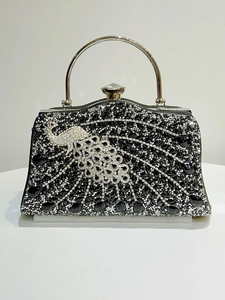 Detail of silver peacock diamond pattern on black evening bag with crystal clasp