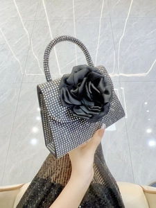 Detail of the black evening bag with a large fabric rose and sparkling rhinestones