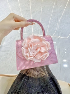 Detail of pink flower handbag with luxury rhinestones and satin rose handle decoration