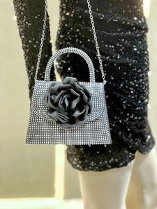 Macro shot of silver rhinestone floral evening bag with a pearl handle and black satin rose