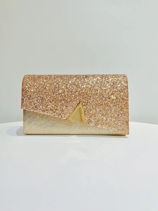 Λεπτομέρεια από τσαντάκι clutch με μεταλλικό κούμπωμα V και παγιέτες σαμπανιζέ χρυσό