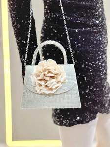 Detail of evening clutch with sparkling rhinestones and a champagne satin flower