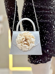 Detailed view of luxury silver rhinestone evening bag with a large satin 3D rose accent