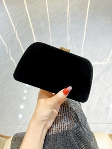 Detail of elegant black velvet evening clutch with a gold rectangular metal clasp