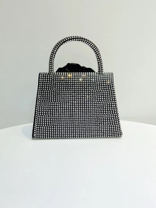 Detailed view of silver rhinestones on a flower evening bag with drawstring liner