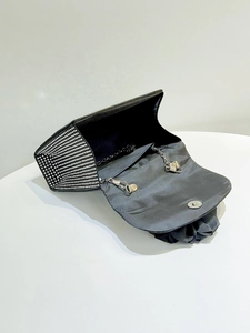 Detail view of black satin evening bag with silver rhinestones and metal chain strap