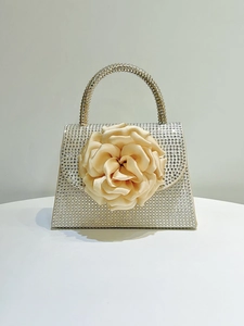 Detail of evening clutch with champagne rhinestones and a 3D satin rose flower accent