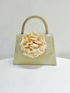 Macro view of crystal encrusted handbag with a large 3D satin rose floral decoration