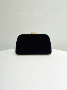 Close-up of black velvet evening clutch bag with elegant golden metal top frame closure