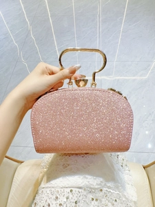 Detalle del bolso de fiesta rosa con purpurina, asa de metal dorado y cierre de gema