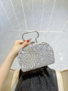 Detalle de bolso de fiesta plateado con pedrería densa y cierre de cristal elegante