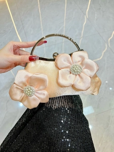 Detail of champagne satin evening bag featuring 3D silk flowers and pearl accents