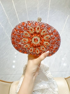 Detailed view of red evening clutch featuring handmade floral rhinestones and crystal clasp