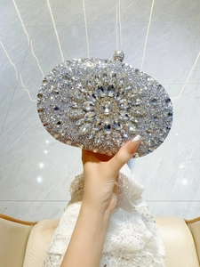 Detail of silver evening clutch bag featuring floral crystal patterns and sparkling rhinestones