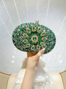 Detailed close-up of emerald and silver rhinestone floral pattern on a luxury clutch bag