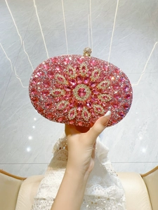 Detailed macro view of the pink crystal floral pattern and sparkling rhinestone clasp on the clutch