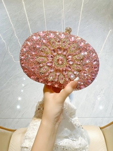 Detail of luxury oval evening clutch with pink crystals and floral rhinestone pattern