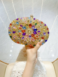 Close-up of a luxury oval evening clutch with colorful rhinestones and floral pattern