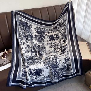Detail of navy blue toile de jouy forest animal print square scarf on leather sofa