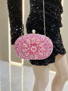 Close-up of pink crystal evening bag featuring floral rhinestone pattern and gold chain