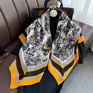 Detail of artistic forest lion print and vibrant orange contrast border on silk scarf