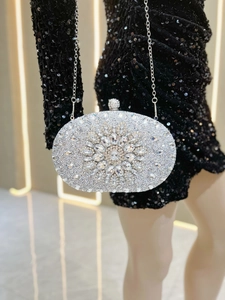 Close-up of silver rhinestone evening clutch bag with pear-shaped crystal floral pattern