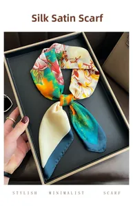 Detailed view of floral silk scarf knot styling on a black tray with orange leaf pattern