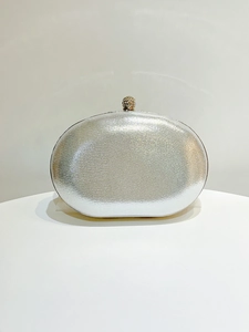 Detail of silver glitter evening clutch bag with a sparkling rhinestone spherical metal clasp