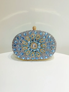 Macro detail of oval clutch bag with blue flower rhinestone pattern and crystal clasp