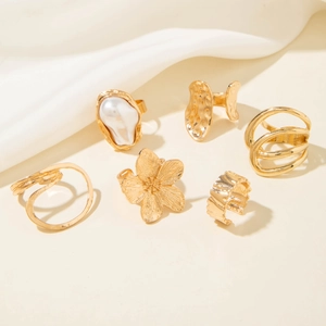 Close-up of a 6-piece gold alloy ring set featuring baroque pearl and floral textures