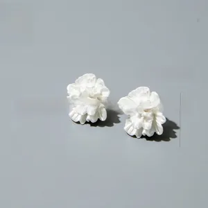 Detail showing matte white layered petal flower earrings with 2.5cm diameter scale