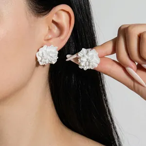 Detail of white 3D floral earrings featuring elegant multilayered petal craftsmanship