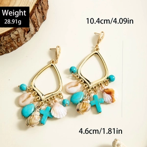 Primer plano de pendientes boho dorados con cuentas de turquesa y colgantes de concha