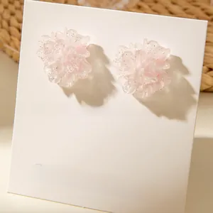 Close-up of pink resin flower earrings with sparkling glitter and textured petals