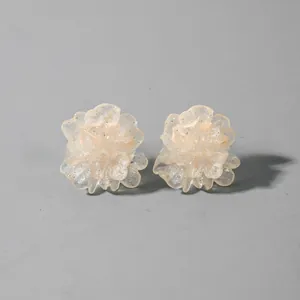 Detailed macro view of 3D blue translucent resin flower earrings with shimmer glitter