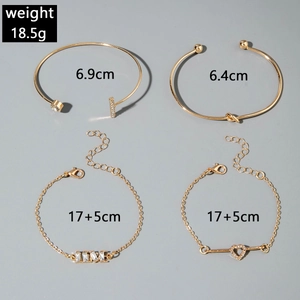 Detail of four-piece gold bracelet set with pearls, zircons and LOVE letter design