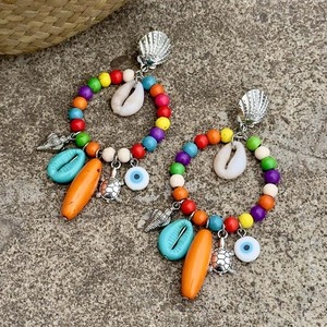 Detalle de pendientes boho estilo océano con conchas y colgantes de tortuga