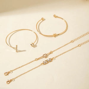 Detail view of a 4-piece gold bangle and bracelet set with LOVE charms and heart motifs