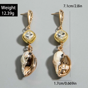 Detalle de pendientes de concha mostrando largo 7,1cm, ancho 1,7cm y datos de peso