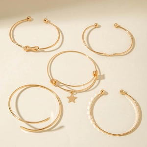 Detailed view of 5-piece gold plated bracelet set with star and infinity charm accents